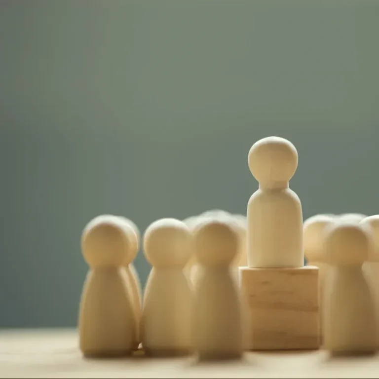 Figurines en bois, une figurine centrale surélevée parmi d'autres.