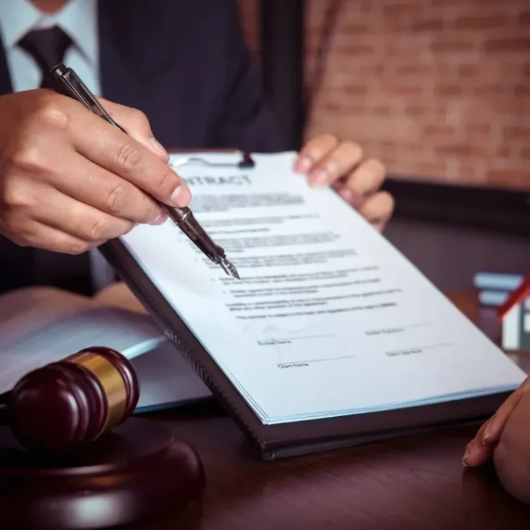 Main tenant signant un contrat avec un gavel sur la table.